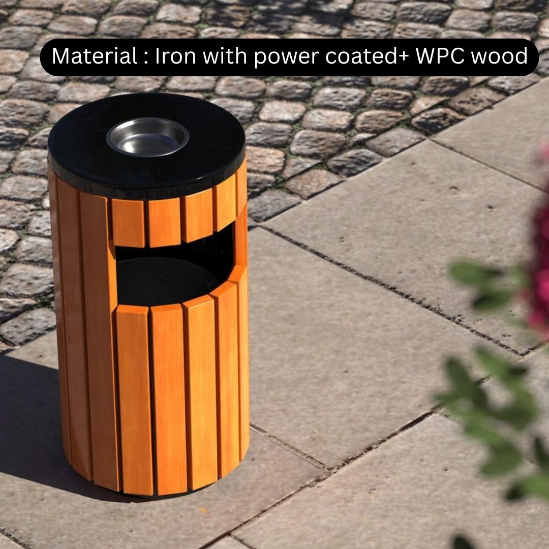 Cylindrical outdoor trash bin with orange and black design on a paved surface.