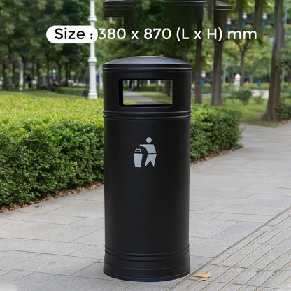 Black cylindrical trash bin with a size label on a park pathway